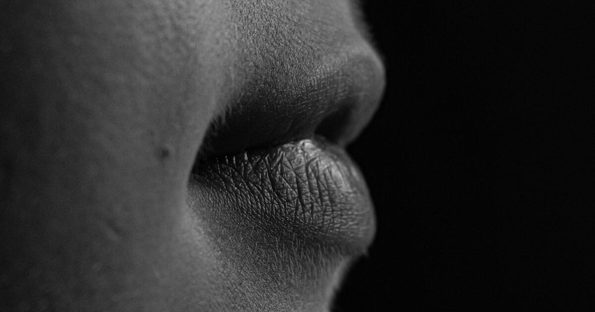 Black and white close-up of lips showing texture and details.