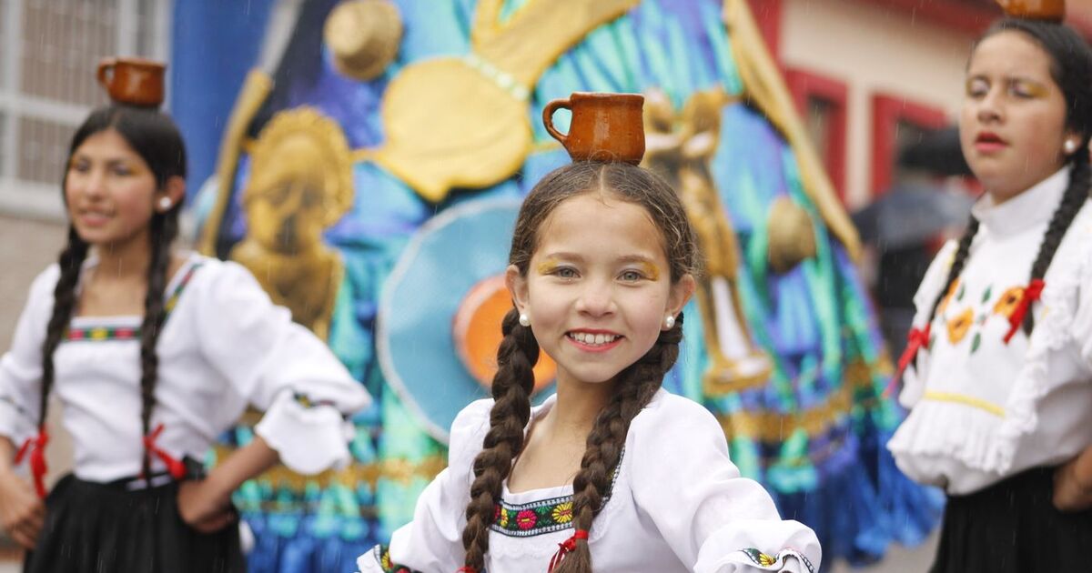 A vibrant celebration in Zipaquirá, Colombia features children in traditional outfits performing with joyful expressions.