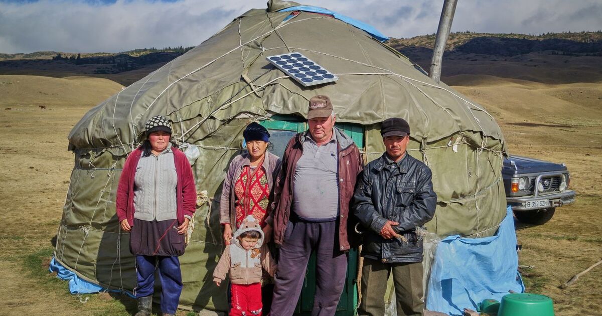 A Mongolian family standing outside a traditional ger in the highlands.