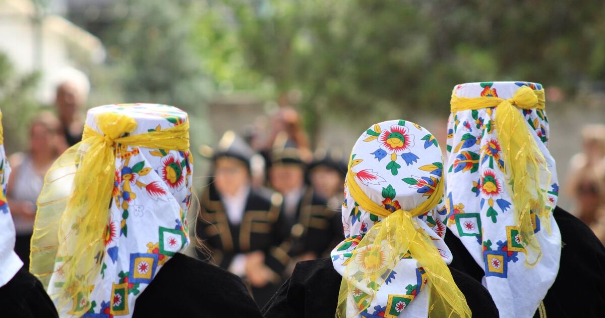 Women in floral patterned headscarves at a traditional outdoor celebration.
