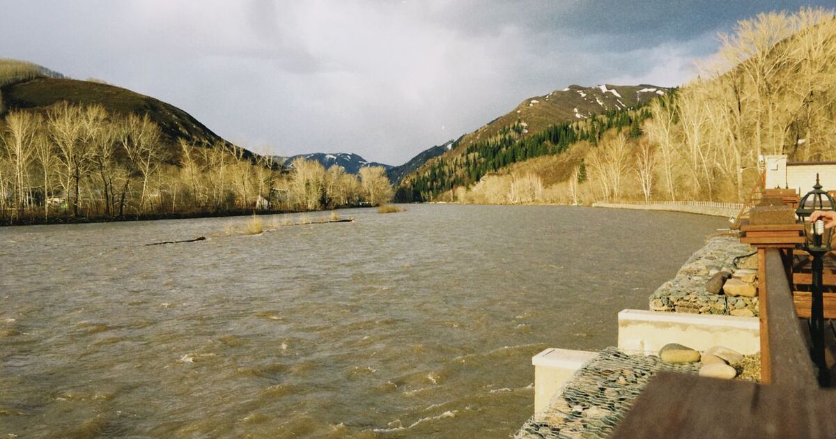 Beautiful river with mountainous landscape in Oskemen, Kazakhstan, under a cloudy sky.