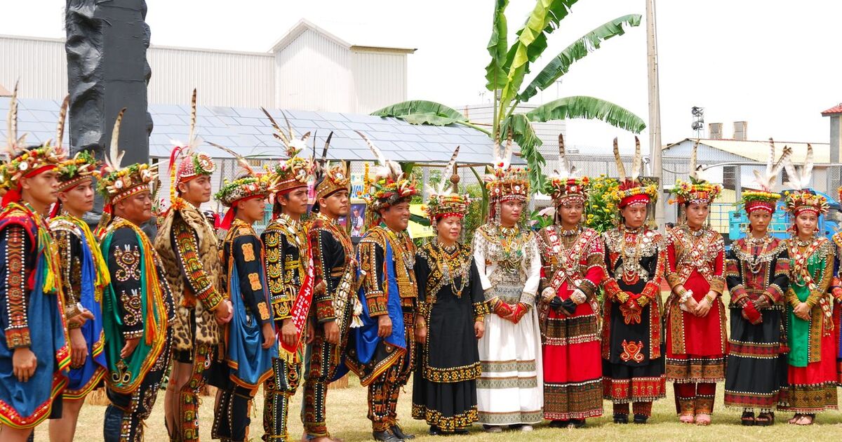 A vibrant display of traditional clothing in a cultural heritage ceremony outdoors.