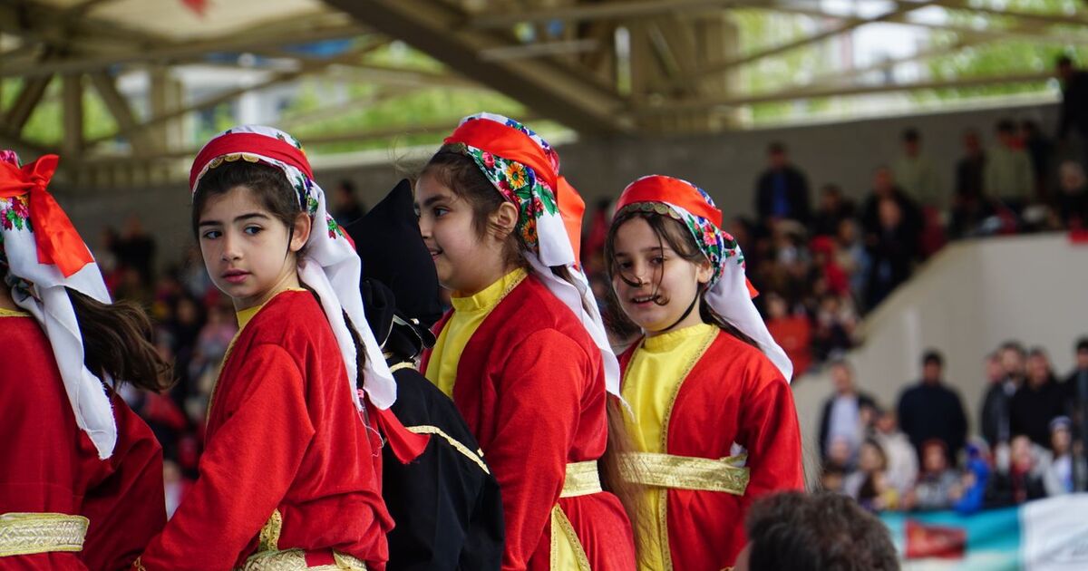 Children in traditional Turkish costumes perform at a festival in Istanbul, Türkiye.