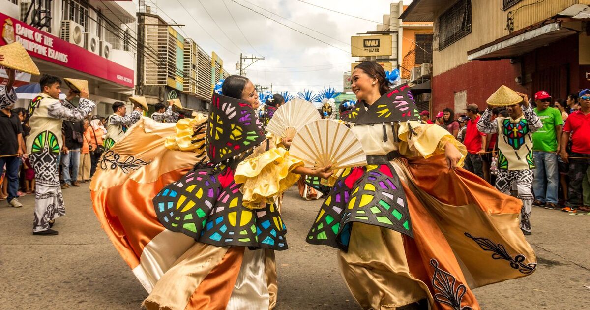 Vibrant street festival with dancers in traditional attire showcasing Filipino culture.