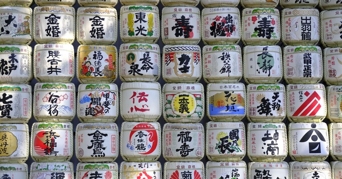 Rows of stacked colorful various aluminum jars with Asian tea in rays of sun in traditional market