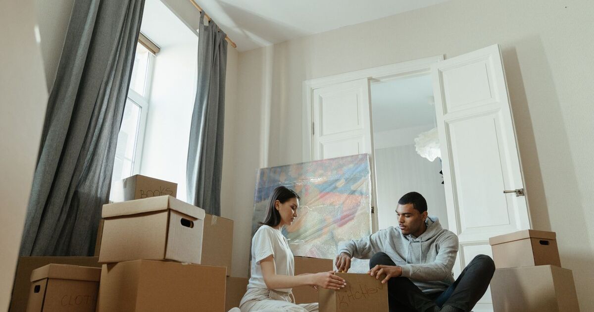 A young couple unpacks boxes in their new apartment, starting their domestic journey.