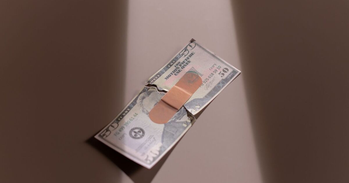 A $50 bill with a bandage symbolizes financial recovery and repair.