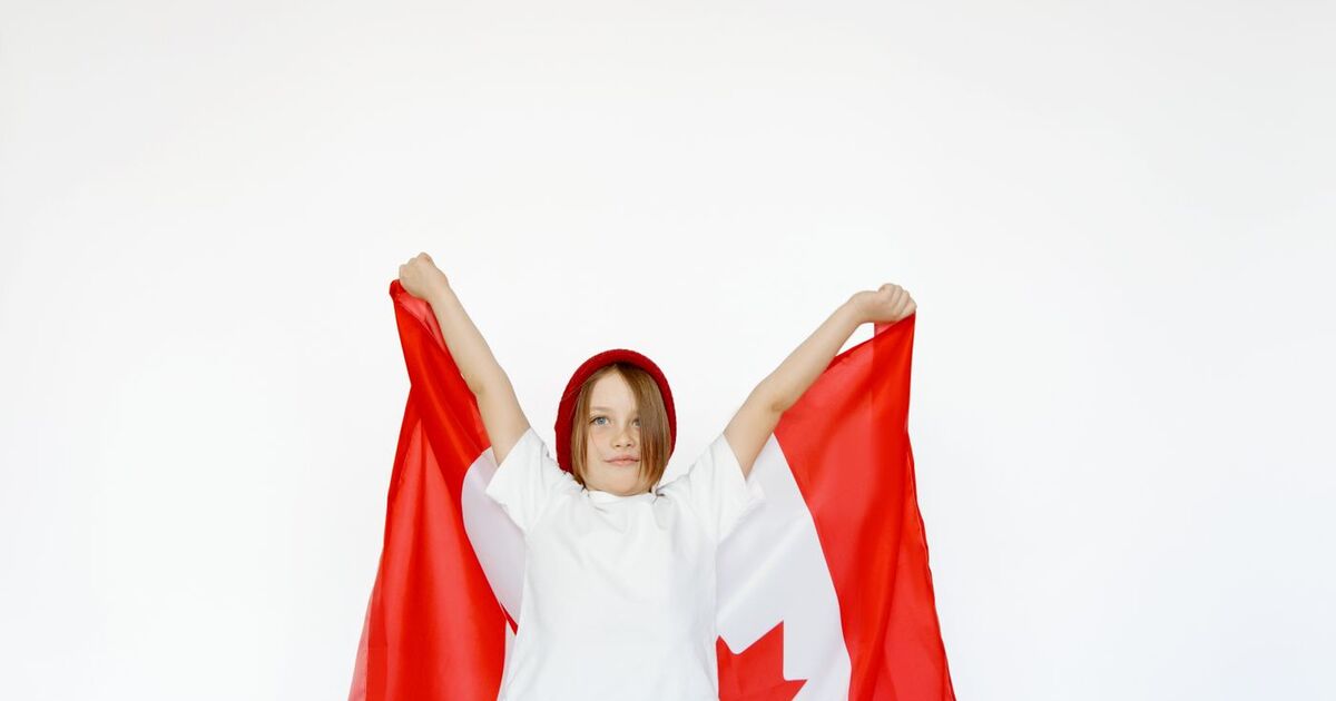 A child joyfully holding a Canadian flag, celebrating patriotism and freedom.