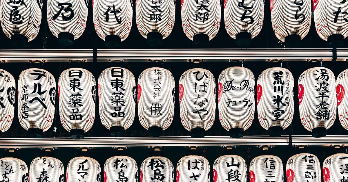 Detailed view of traditional Japanese paper lanterns with kanji characters, creating a cultural ambiance.
