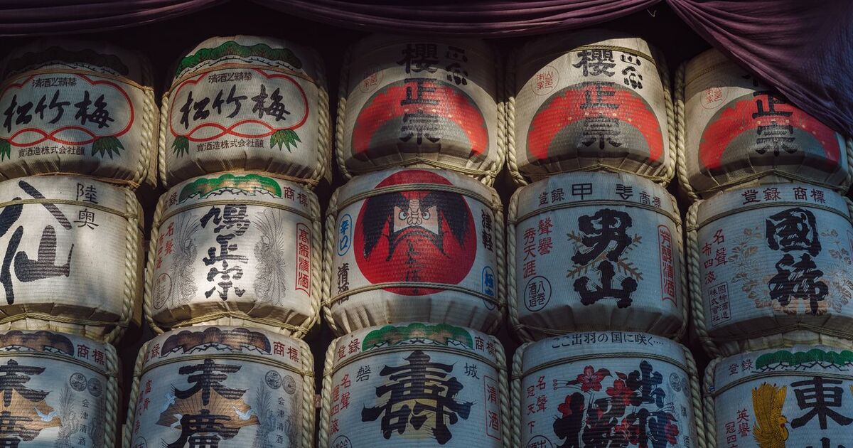 Sunlit display of traditional sake barrels in Shibuya, Tokyo, showcasing Japanese aesthetics.